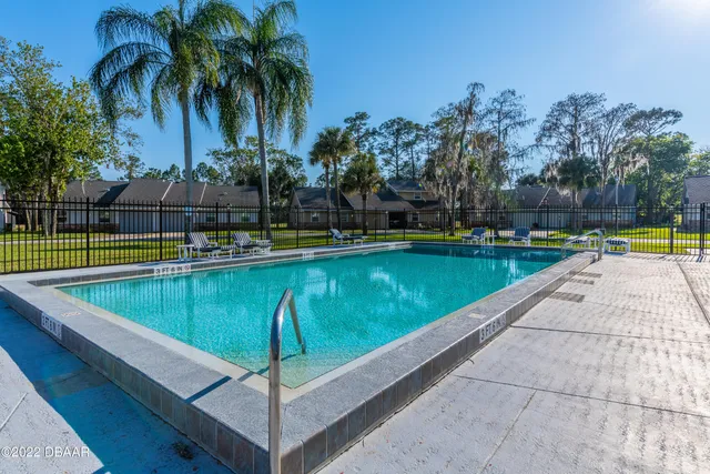 a view of a swimming pool with a patio and a yard