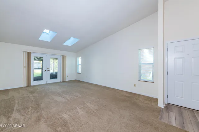 an empty room with windows and cabinet