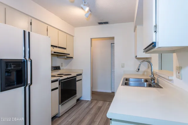 a kitchen with stainless steel appliances a stove a refrigerator and cabinets