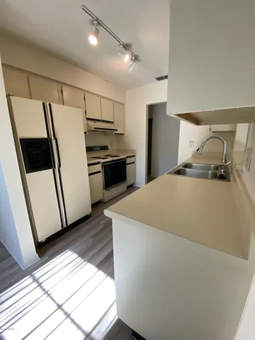 a kitchen with stainless steel appliances a refrigerator a sink and a stove