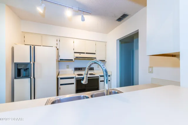 a kitchen with stainless steel appliances kitchen island a refrigerator sink and stove