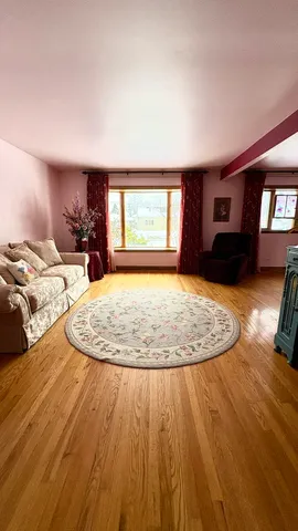 a view of a livingroom with wooden floor and a fireplace