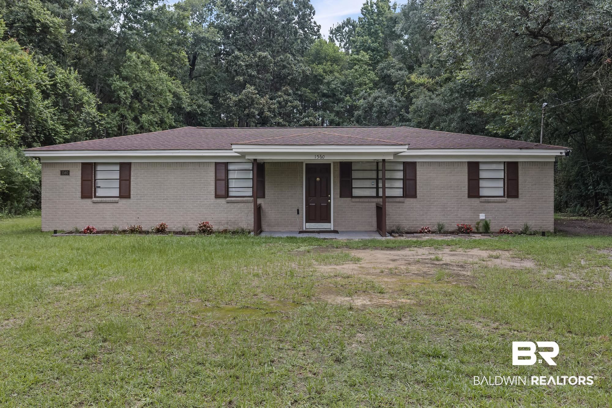 1560 Military Road Mount Vernon, AL 36560 - Photo 1 of 26 Brick exterior residence featuring a brown shingle roof and contrasting dark brown shutters