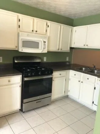a kitchen with white cabinets and appliances