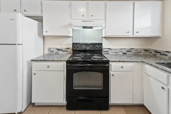 a kitchen with a sink stove and cabinets