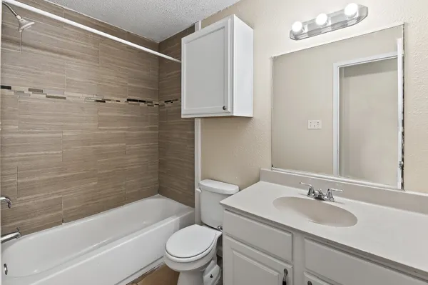 a view of backyard with large tree and wooden fence