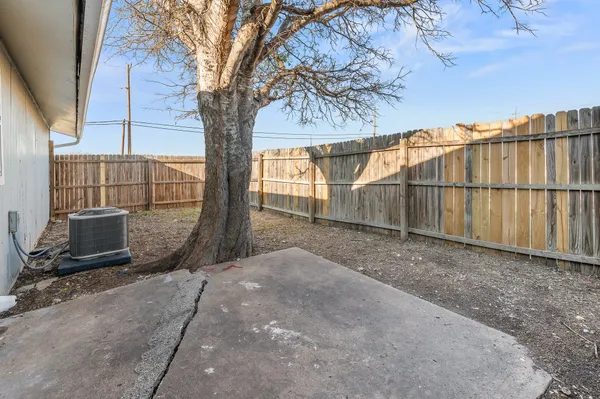 a view of a house with a tree and a wooden fence