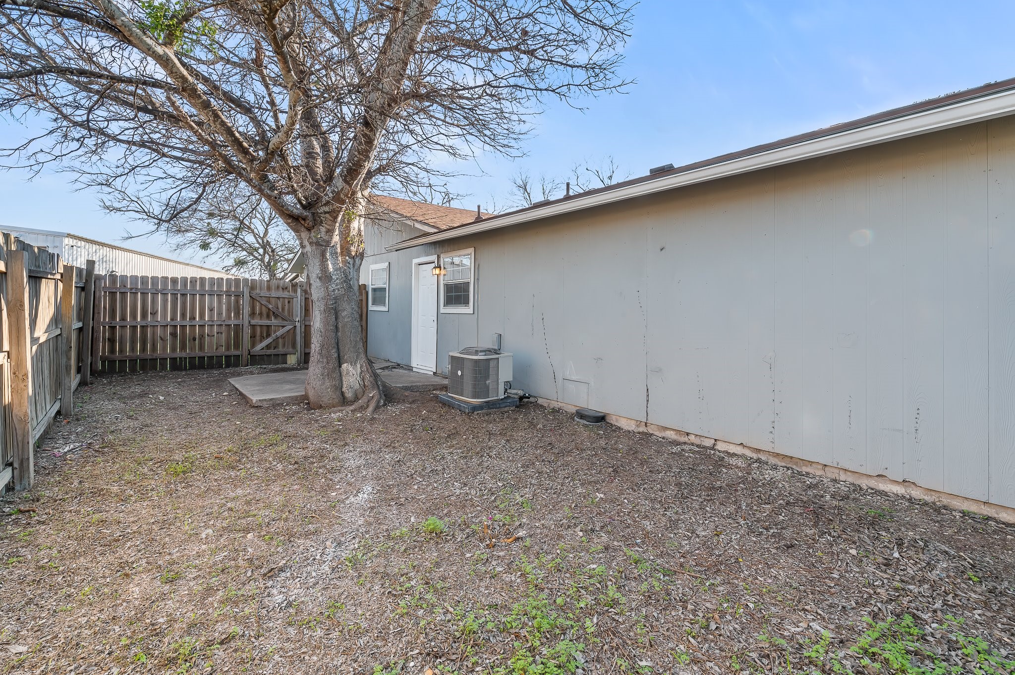 410 Old Thorndale Road, Unit A Taylor, TX 76574 - Photo 27 of 28 a backyard of a house with a large tree and wooden fence