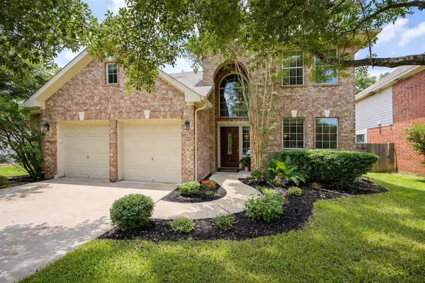 a front view of a house with a yard and garage