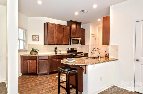 a kitchen with stainless steel appliances granite countertop a sink stove and refrigerator