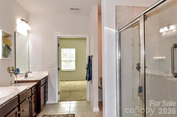 a bathroom with a double vanity sink mirror and shower