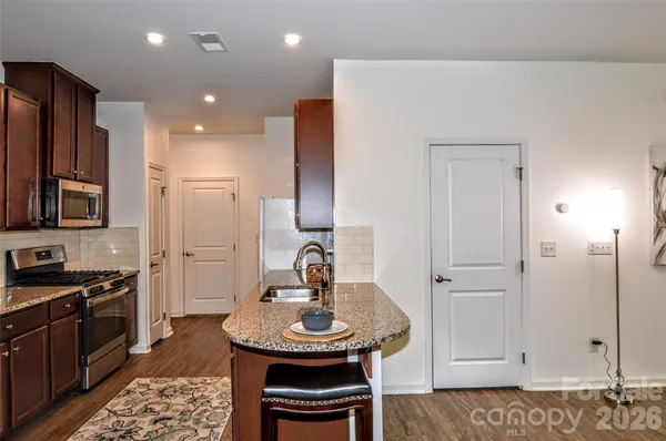 a kitchen with stainless steel appliances a sink cabinets and wooden floor