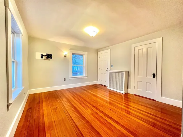 a view of a room with wooden floor and white walls