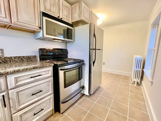 a kitchen with granite countertop a stove microwave and cabinets