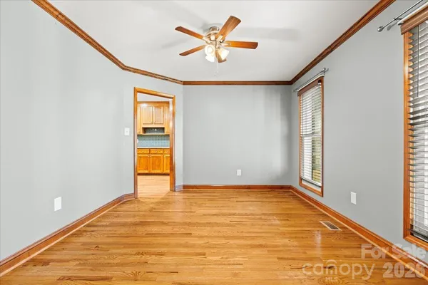 an empty room with window and ceiling fan