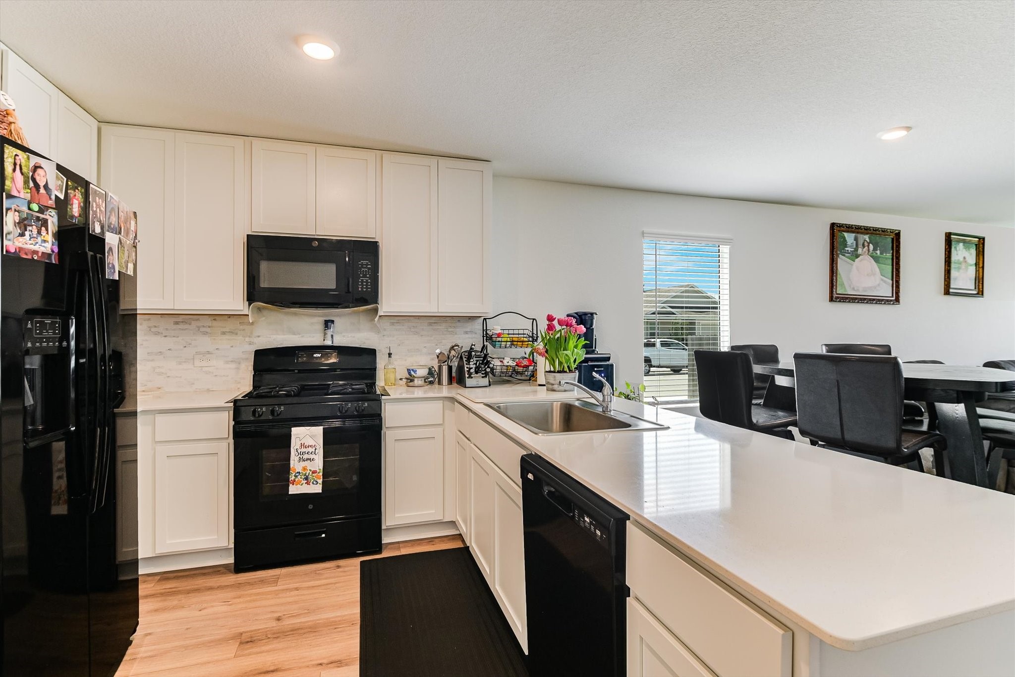 2223 Cumulus Court Lockhart, TX 78644 - Photo 8 of 20 a kitchen with stainless steel appliances a stove refrigerator sink and white cabinets