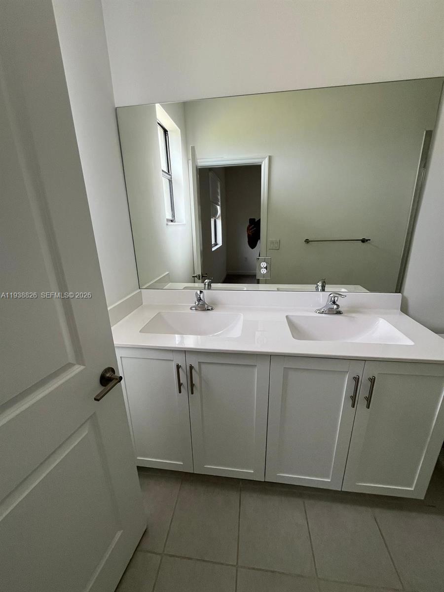 9941 Southwest 228th Terrace, Unit 9941 Miami, FL 33190 - Photo 12 of 31 a bathroom with a sink and a mirror