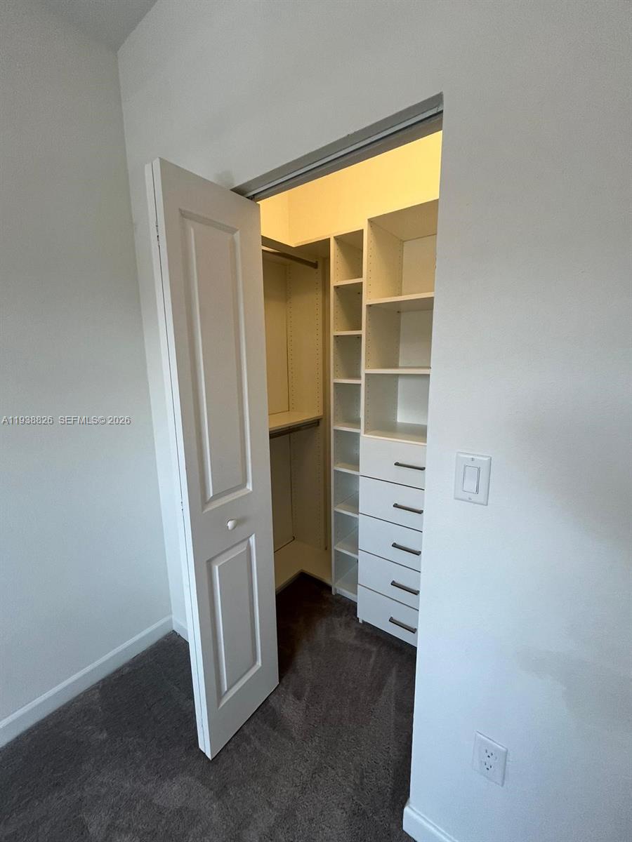 9941 Southwest 228th Terrace, Unit 9941 Miami, FL 33190 - Photo 20 of 31 a view of walk in closet with empty racks