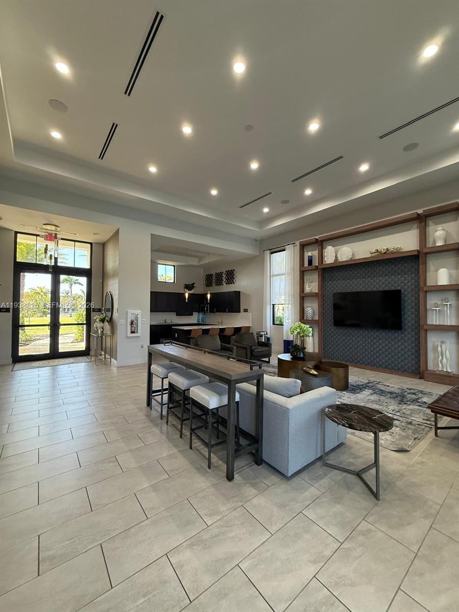 9941 Southwest 228th Terrace, Unit 9941 Miami, FL 33190 - Photo 26 of 31 a living room with furniture and a flat screen tv