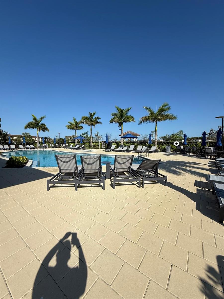 9941 Southwest 228th Terrace, Unit 9941 Miami, FL 33190 - Photo 30 of 31 a swimming pool with outdoor seating and yard