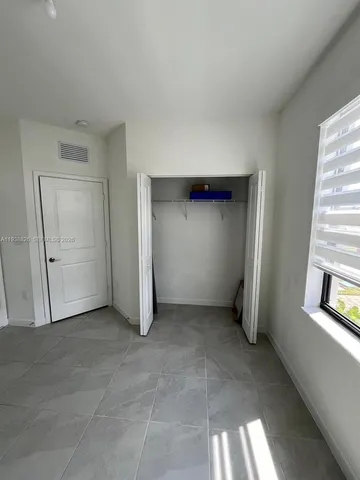 an empty room with windows and closet