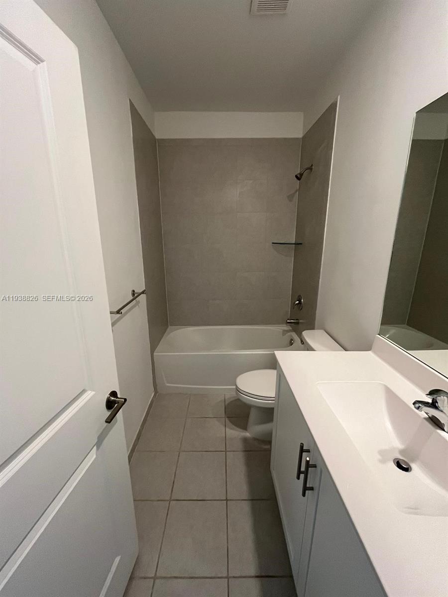 9941 Southwest 228th Terrace, Unit 9941 Miami, FL 33190 - Photo 7 of 31 a bathroom with a sink a toilet and shower