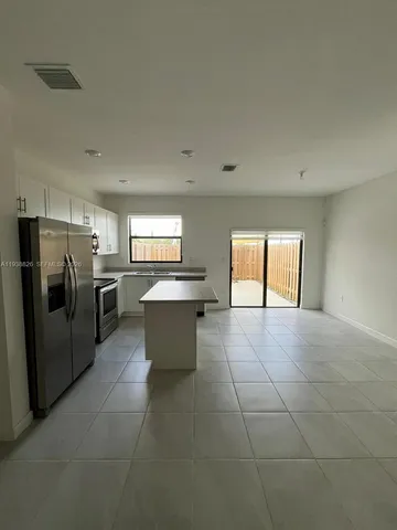 a large kitchen with a stove a refrigerator and a sink