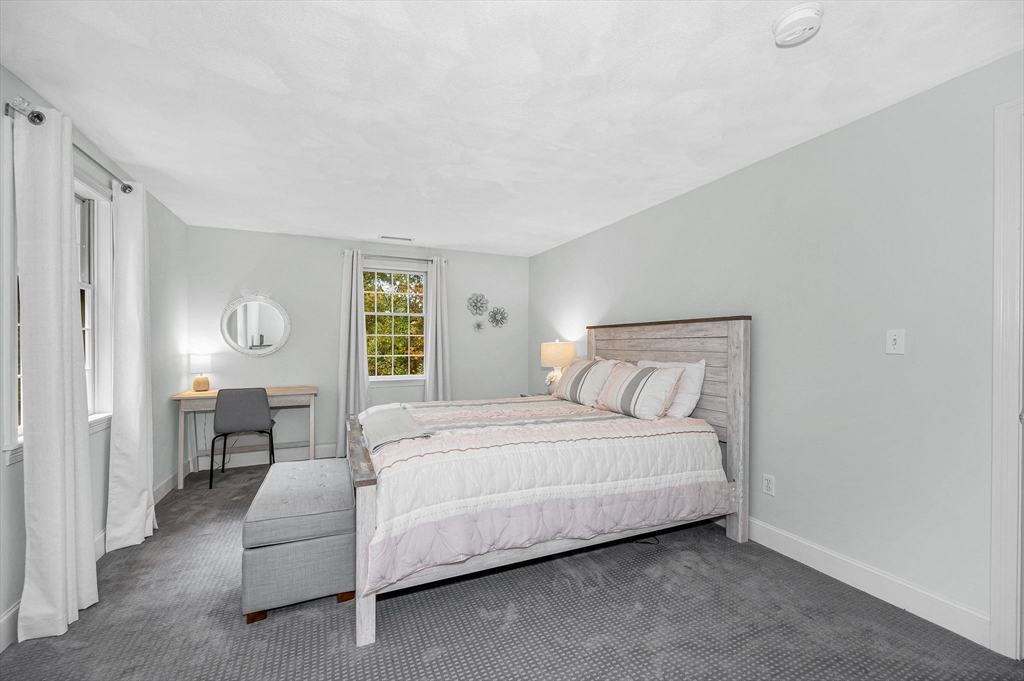 4 Coleman Road Newbury, MA 01922 - Photo 25 of 42 a spacious bedroom with a bed a table and painting