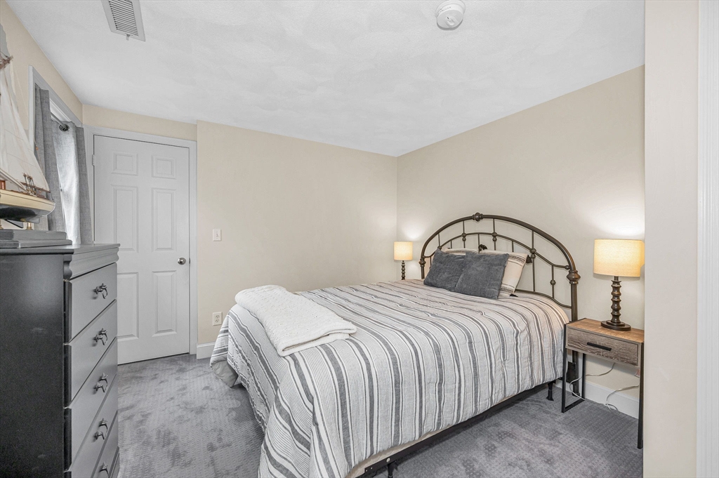 4 Coleman Road Newbury, MA 01922 - Photo 33 of 42 a bedroom with a bed and a mirror