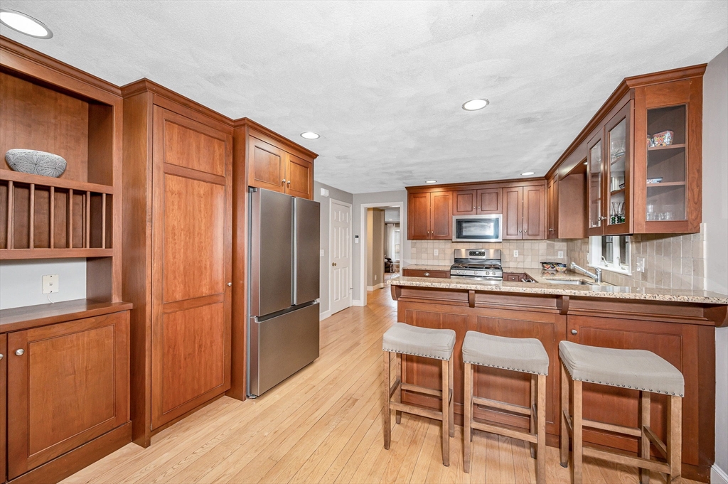 4 Coleman Road Newbury, MA 01922 - Photo 10 of 42 a kitchen with stainless steel appliances granite countertop a refrigerator and wooden cabinets