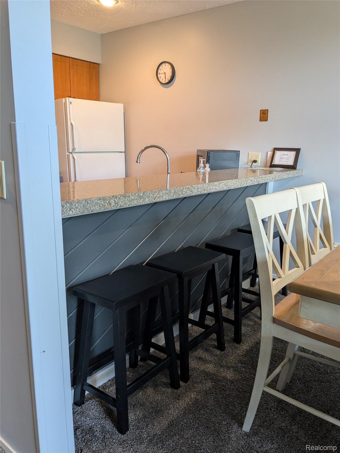 4749 South Pleasantview Road, Unit 20 Harbor Springs, MI 49740 - Photo 8 of 44 High Top Seating at the Kitchen Counter with Dining Room Behind It