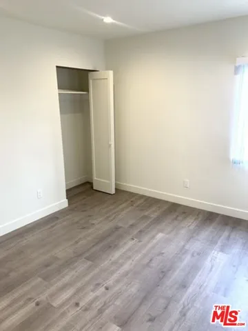 an empty room with wooden floor and closet