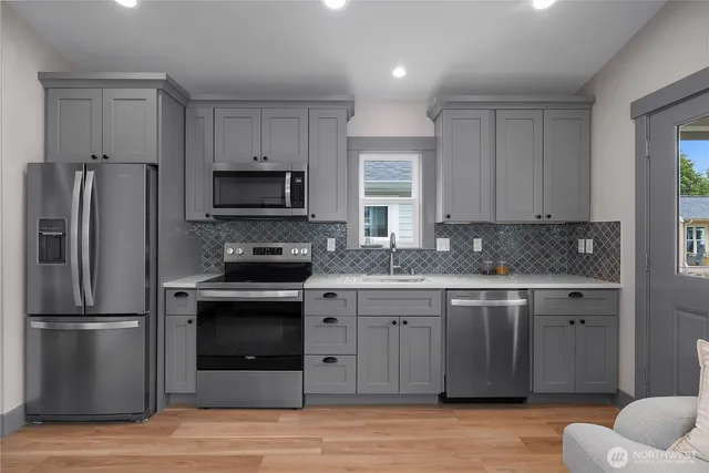 a kitchen with stainless steel appliances granite countertop a stove a refrigerator and a sink