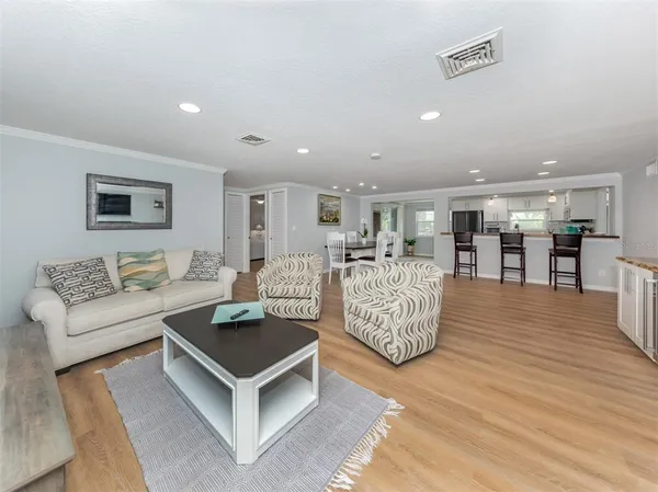 a kitchen with stainless steel appliances granite countertop a table chairs stove and wooden floor