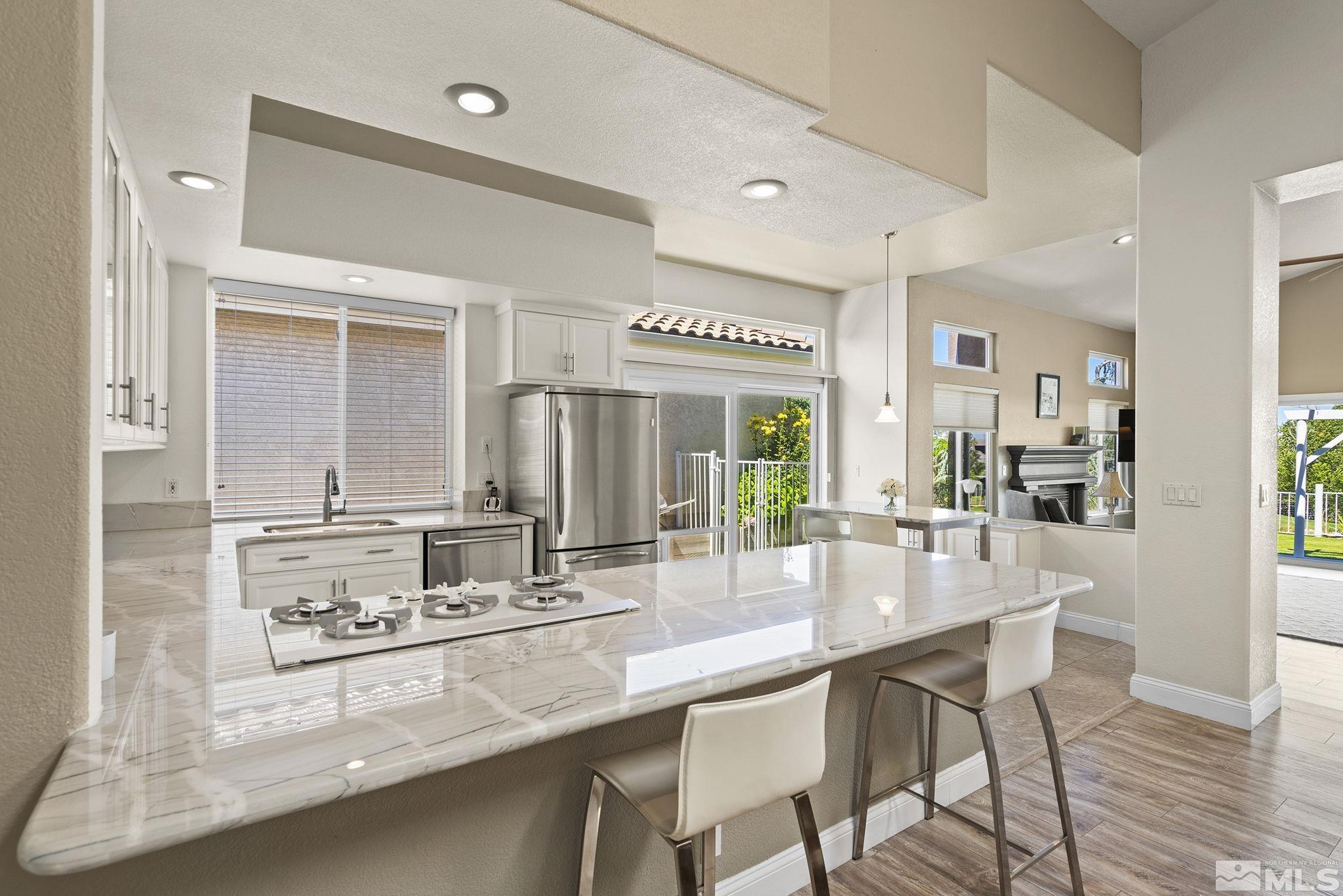 2553 Granite Springs Road Reno, NV 89519 - Photo 17 of 38 a dining hall with stainless steel appliances kitchen island granite countertop a table chairs and a refrigerator
