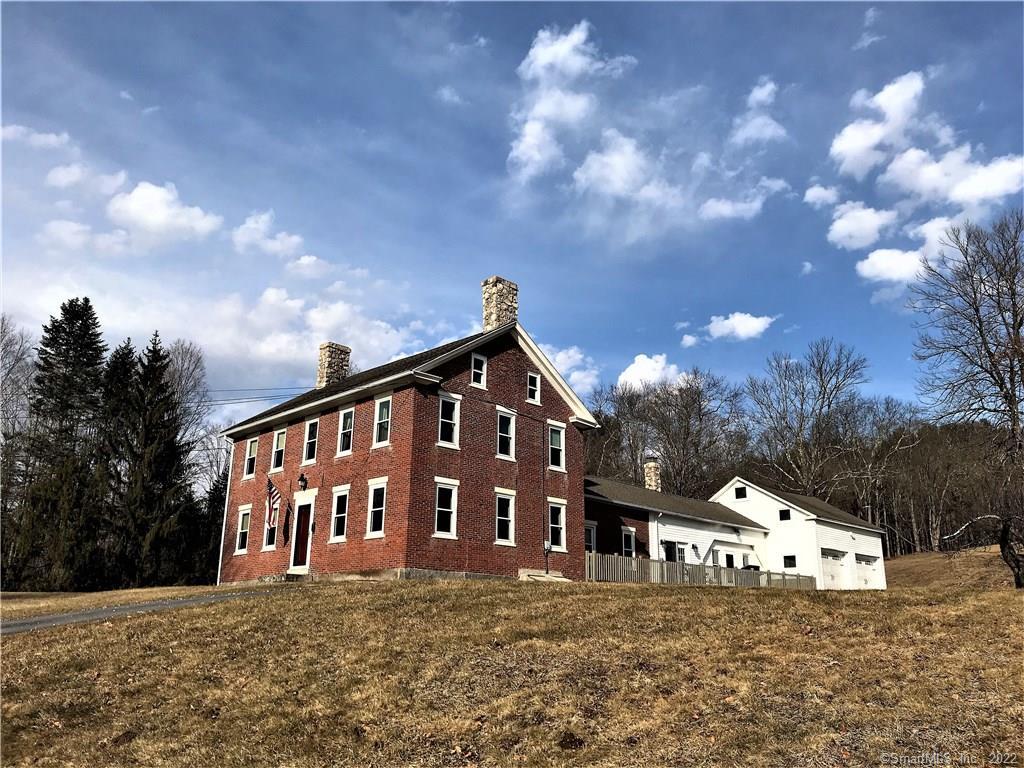 a front view of house with yard and trees in the background