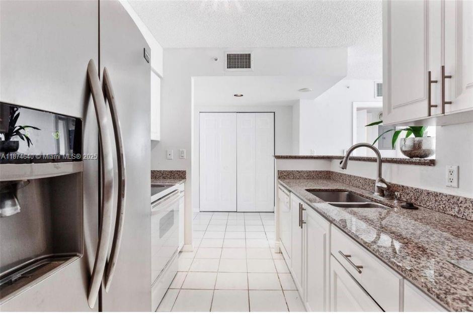 1155 Brickell Bay Drive, Unit 1705 Miami, FL 33131 - Photo 3 of 8 a kitchen with granite countertop a sink stove and refrigerator
