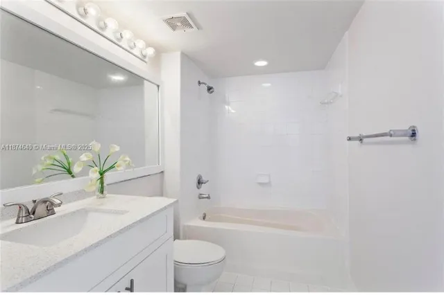 a bathroom with a granite countertop sink a toilet a mirror and shower