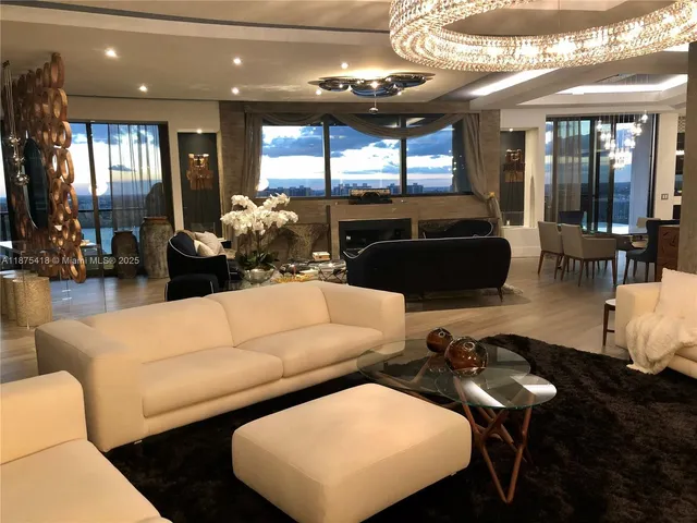 a living room with furniture and a chandelier