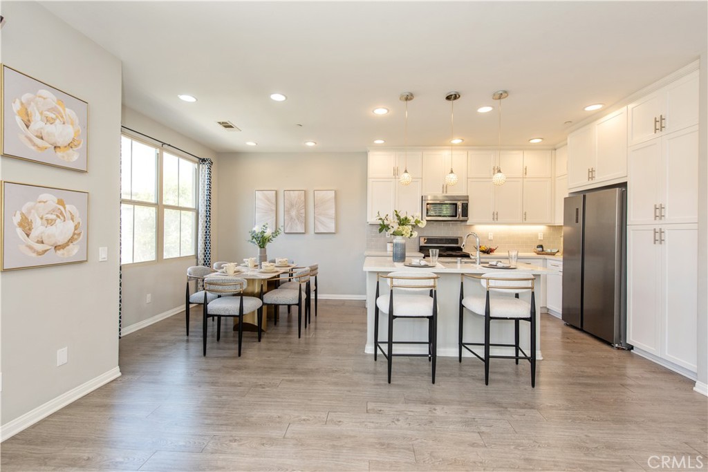 68 Origin Irvine, CA 92618 - Photo 10 of 43 a kitchen with a dining table chairs wooden floor appliances and cabinets