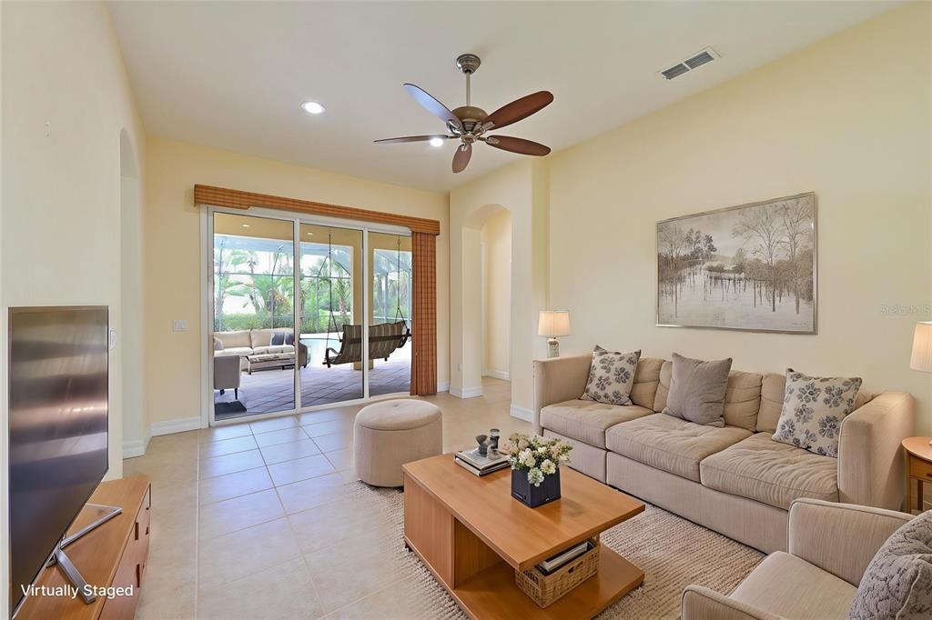 10622 Conch Shell Terrace Bradenton, FL 34212 - Photo 31 of 69 a living room with furniture a clock and a large window