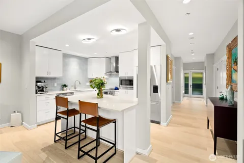 a kitchen with stainless steel appliances kitchen island granite countertop a refrigerator and cabinets