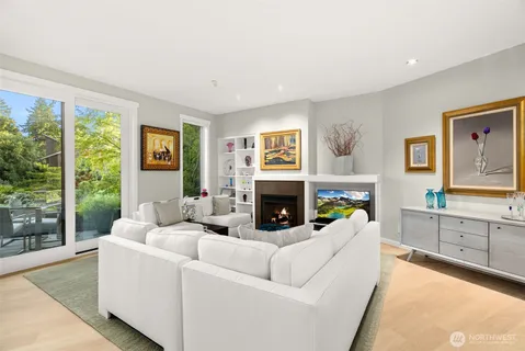 a living room with furniture a fireplace and a large window