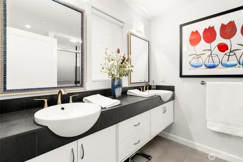 a bathroom with a double vanity sink and a mirror