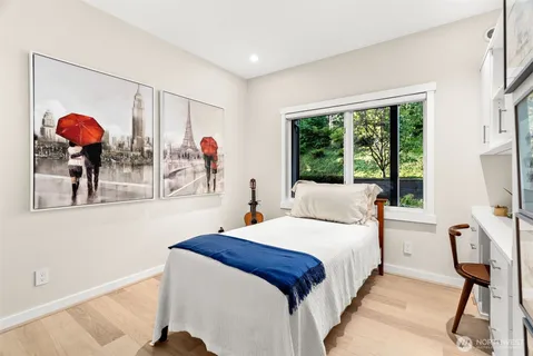a bedroom with a bed a chandelier and a large window