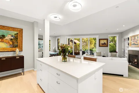 a large living room with stainless steel appliances furniture a chandelier and a flat screen tv