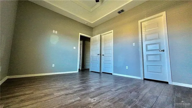 an empty room with wooden floor and closet