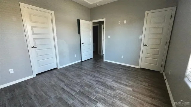 an empty room with wooden floor and closet