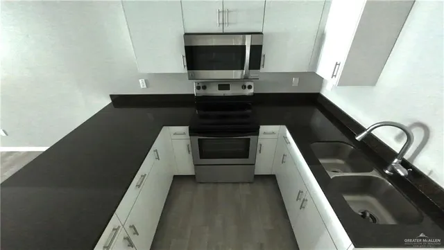 a kitchen with a sink and a stove top oven