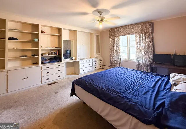 a spacious bedroom with a bed and furniture with window